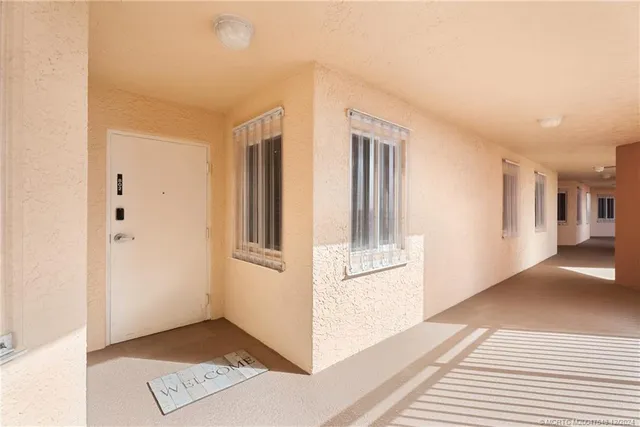 a view of a hallway with wooden floor and cabinet
