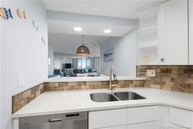 a view with a sink and a refrigerator in a kitchen