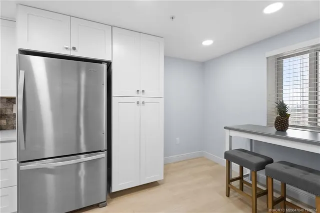 a metallic refrigerator freezer sitting in a kitchen