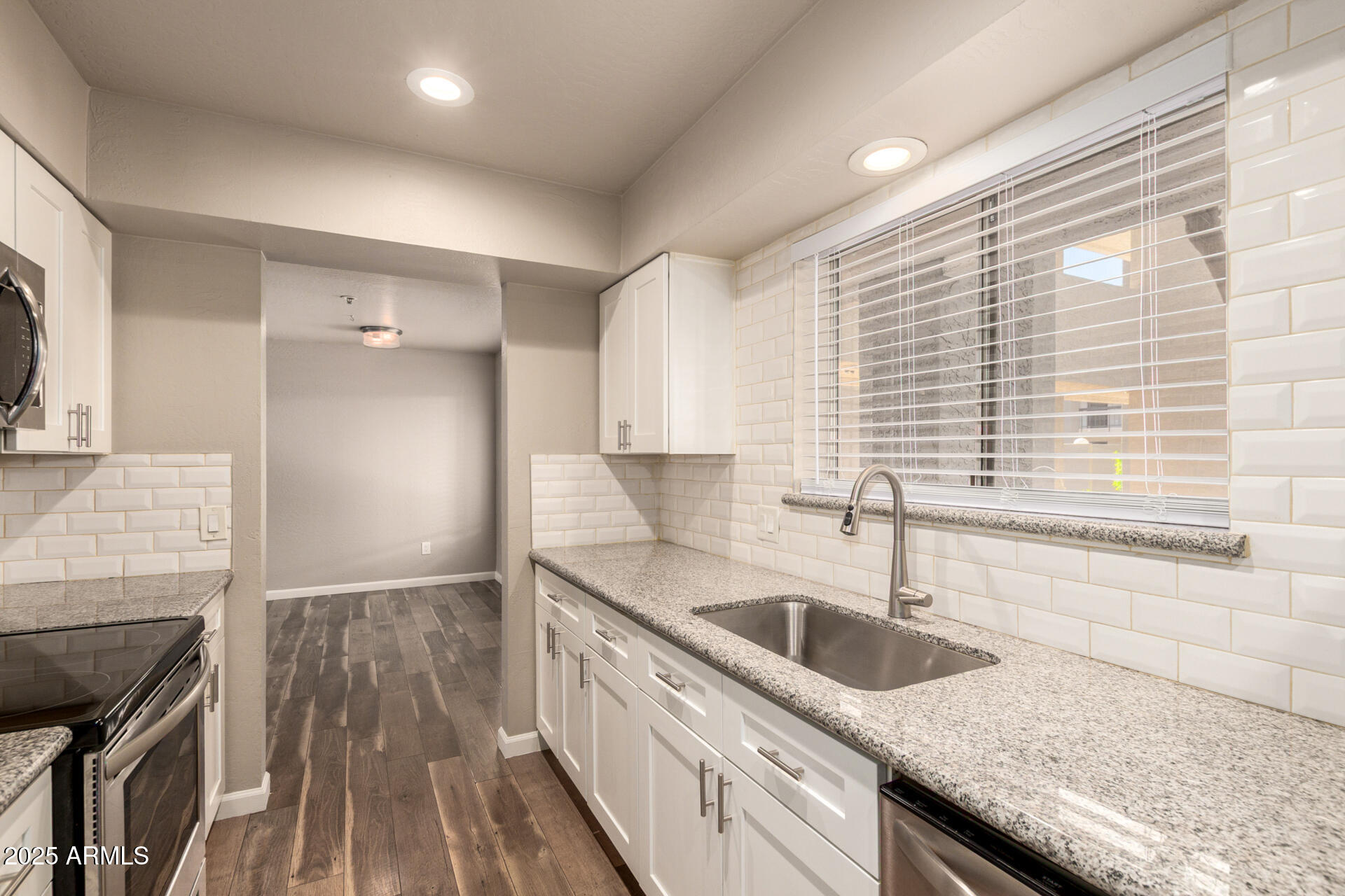 7494 East Earll Drive, Unit 107 Scottsdale, AZ 85251 - Photo 11 of 23 a kitchen with granite countertop a sink and a stove