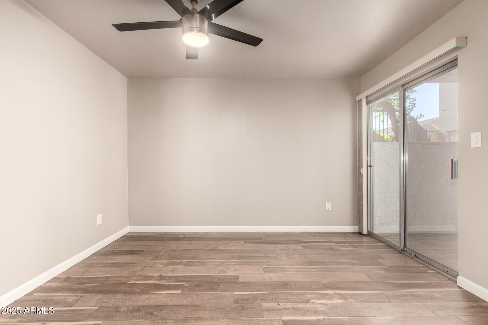 7494 East Earll Drive, Unit 107 Scottsdale, AZ 85251 - Photo 13 of 23 a view of an empty room with wooden floor and a window