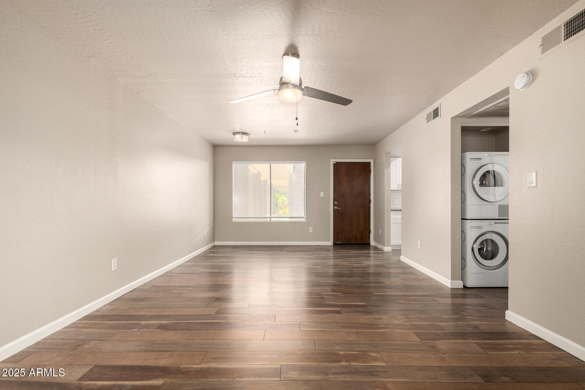 7494 East Earll Drive, Unit 107 Scottsdale, AZ 85251 - Photo 4 of 23 a view of an empty room with window and wooden floor