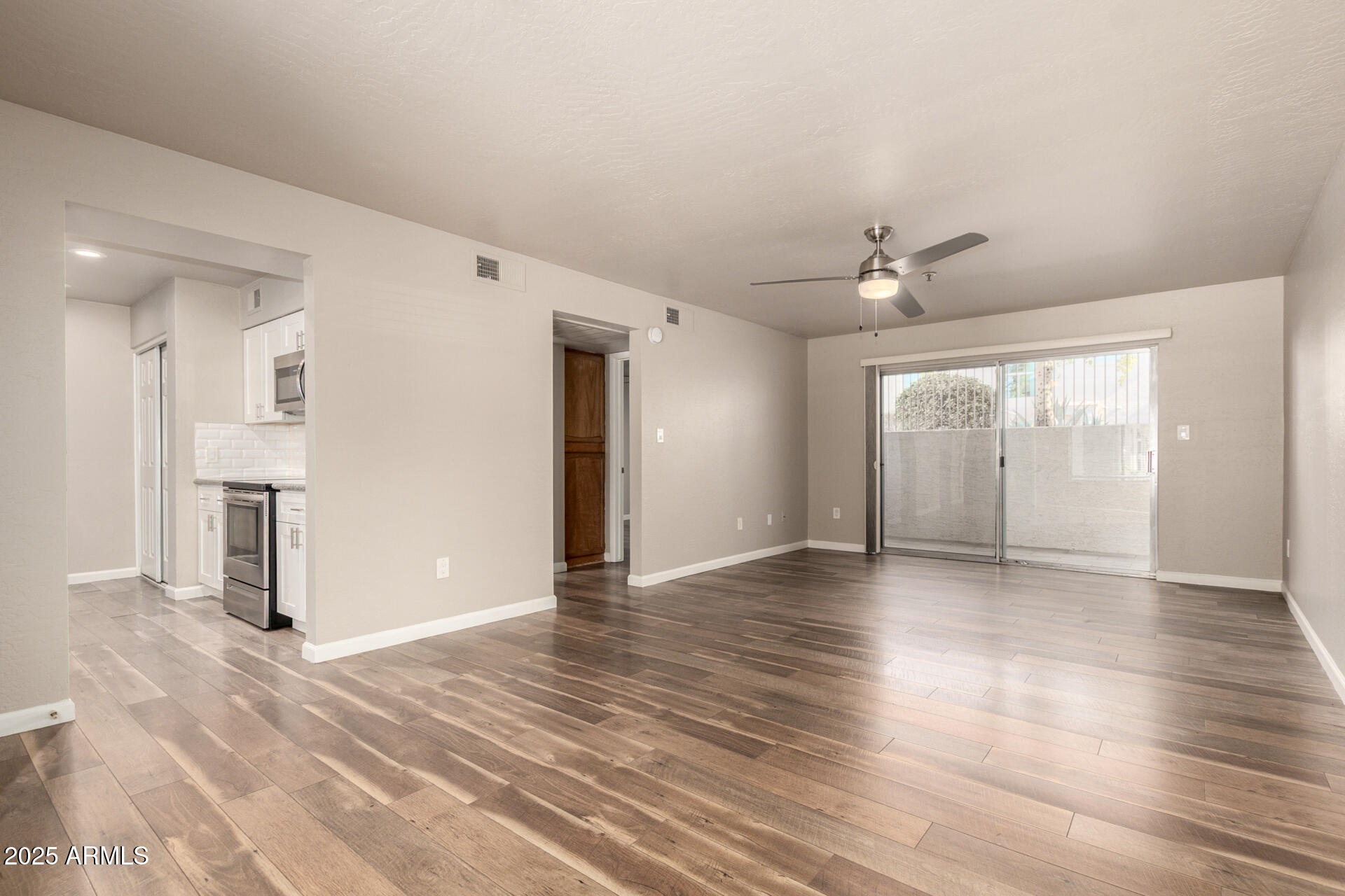 7494 East Earll Drive, Unit 107 Scottsdale, AZ 85251 - Photo 5 of 23 a view of an empty room with wooden floor and a window