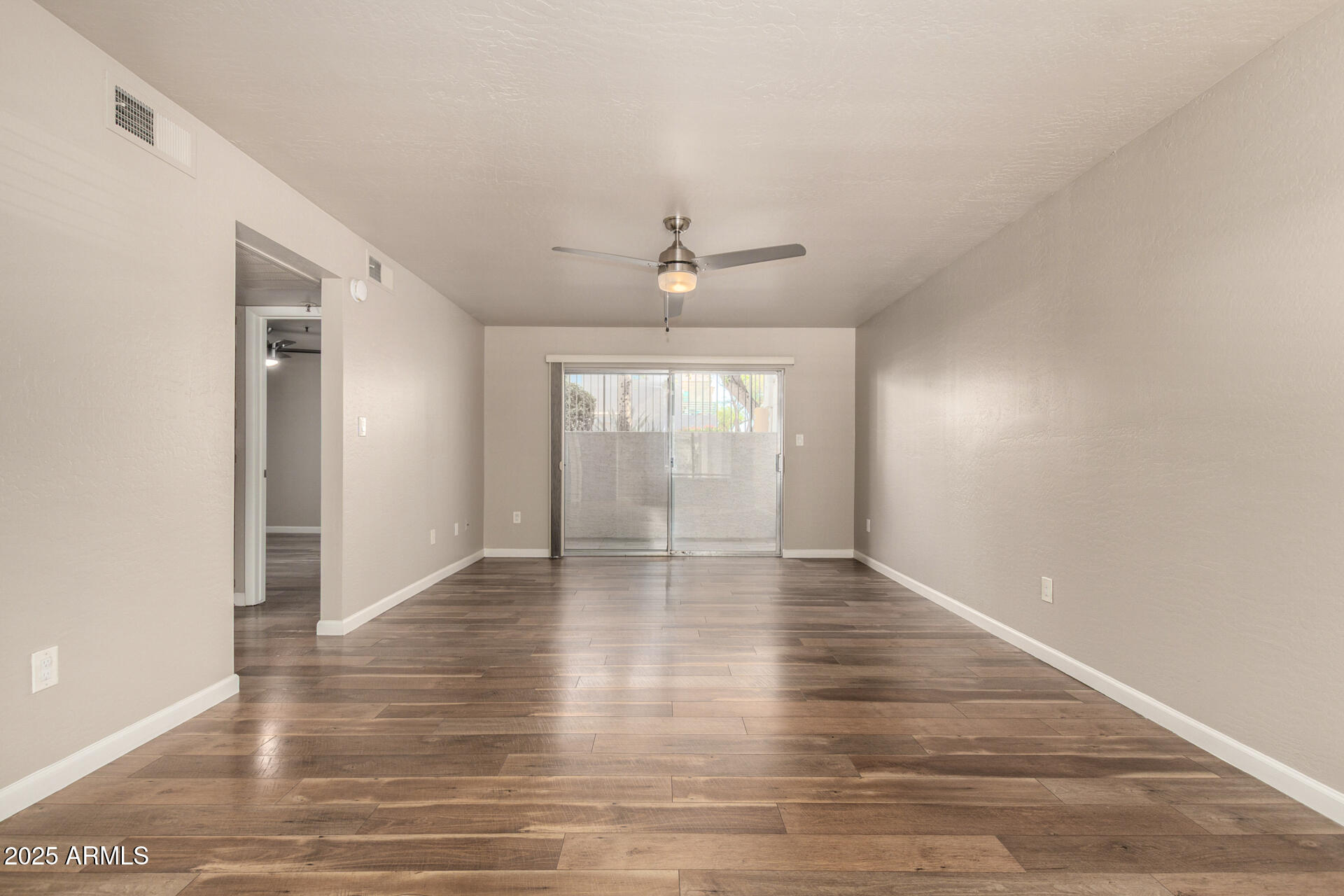 7494 East Earll Drive, Unit 107 Scottsdale, AZ 85251 - Photo 7 of 23 a view of an empty room with wooden floor and a window