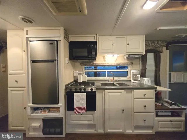 a kitchen with stainless steel appliances granite countertop a refrigerator stove and sink