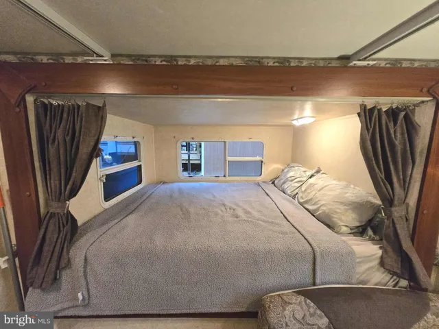 a bed sitting in a bedroom next to a window