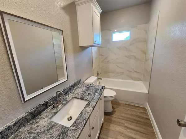 a bathroom with a granite countertop sink toilet and shower