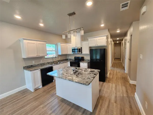 a kitchen with stainless steel appliances granite countertop a sink stove and refrigerator