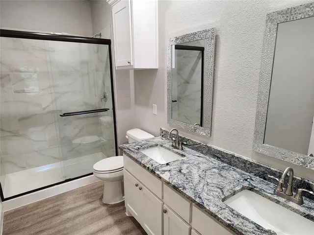 a bathroom with a granite countertop sink toilet and shower