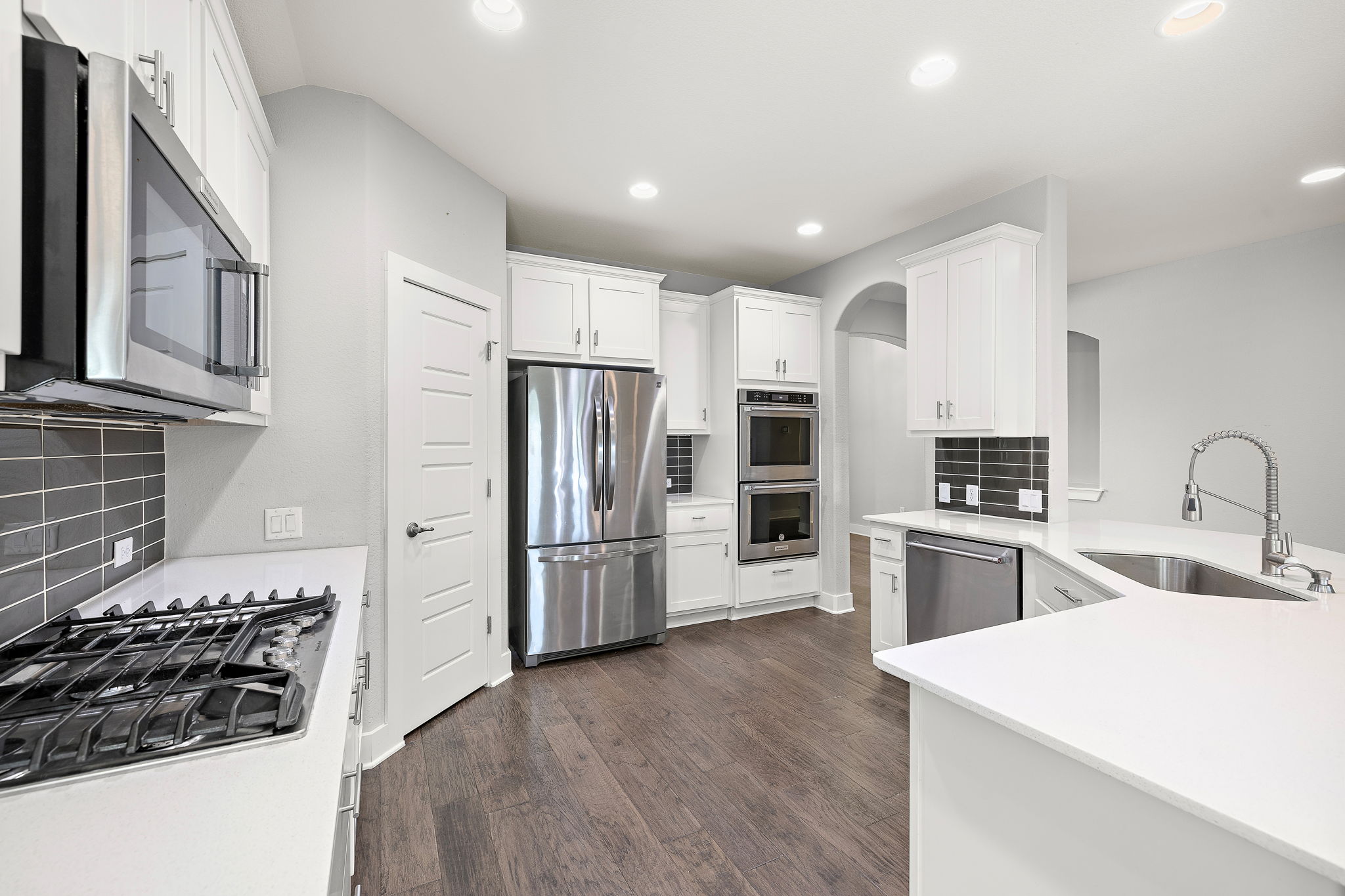 7520 Kinross Trail Austin, TX 78754 - Photo 12 of 37 Kitchen featuring tasteful backsplash, stainless steel appliances, white cabinetry, dark wood-style floors, and light stone countertops