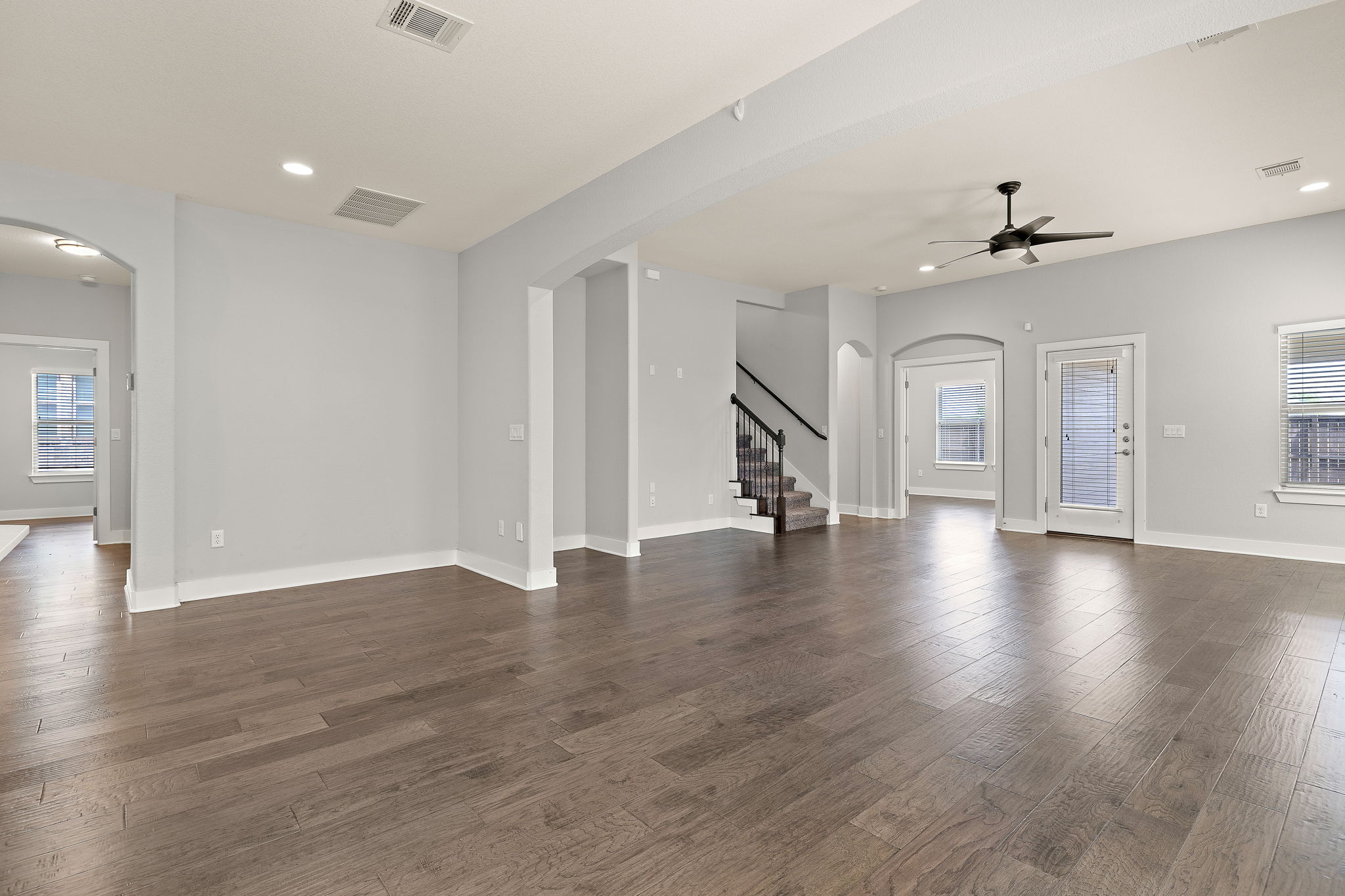7520 Kinross Trail Austin, TX 78754 - Photo 15 of 37 Unfurnished living room with arched walkways, recessed lighting, dark wood finished floors, and a ceiling fan