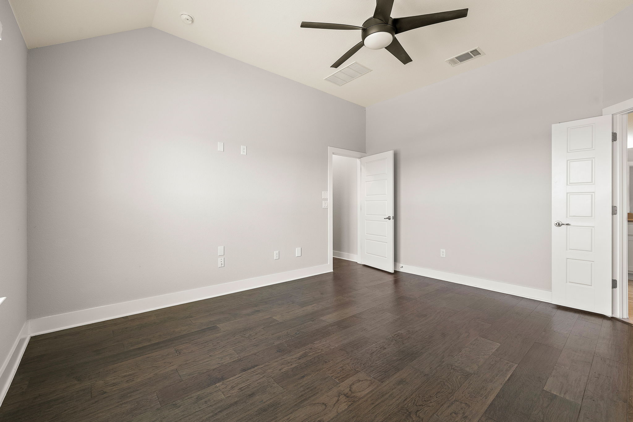 7520 Kinross Trail Austin, TX 78754 - Photo 21 of 37 Empty room featuring vaulted ceiling, dark wood-style flooring, and a ceiling fan