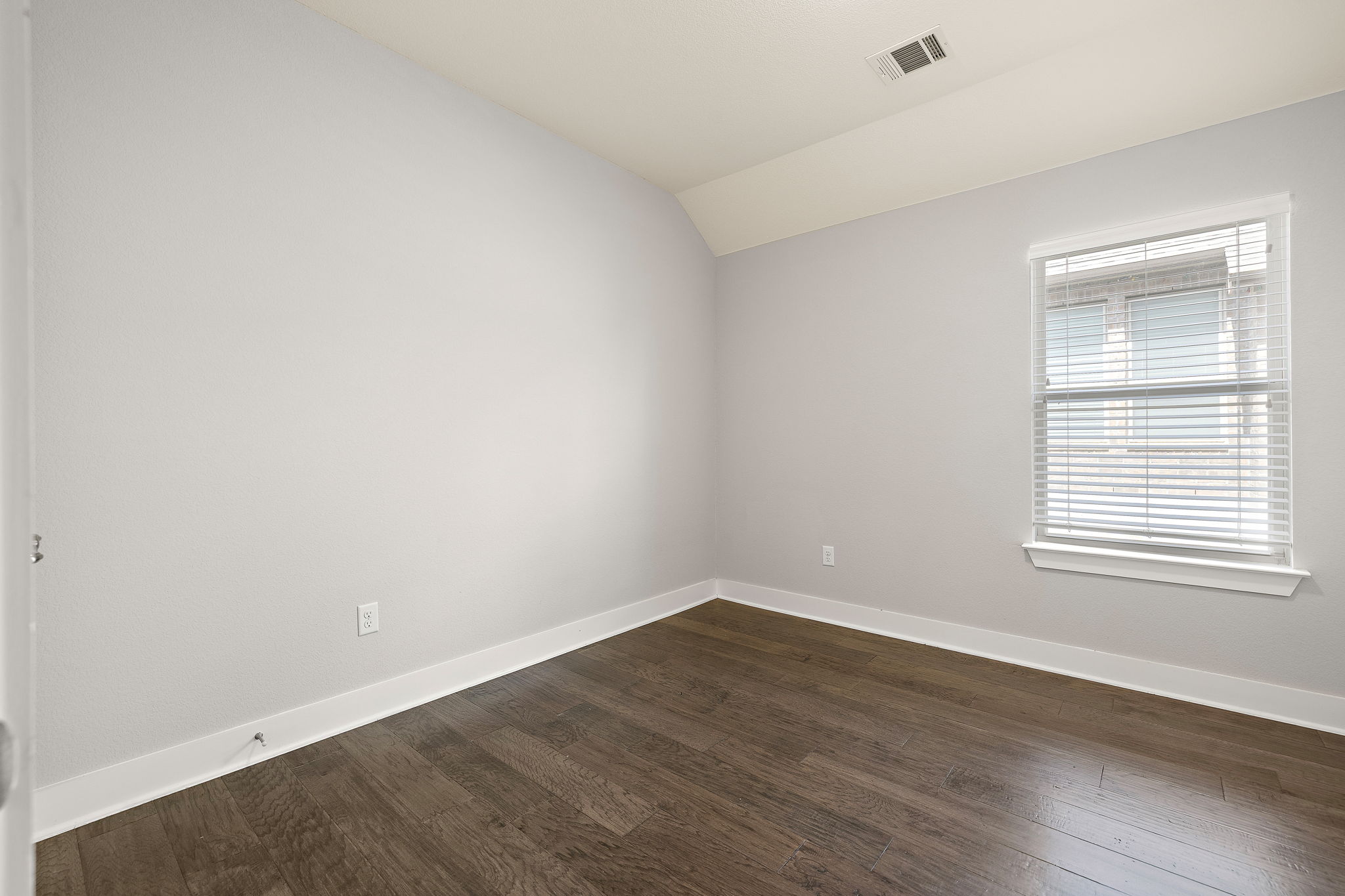 7520 Kinross Trail Austin, TX 78754 - Photo 24 of 37 Empty room with dark wood-type flooring and vaulted ceiling