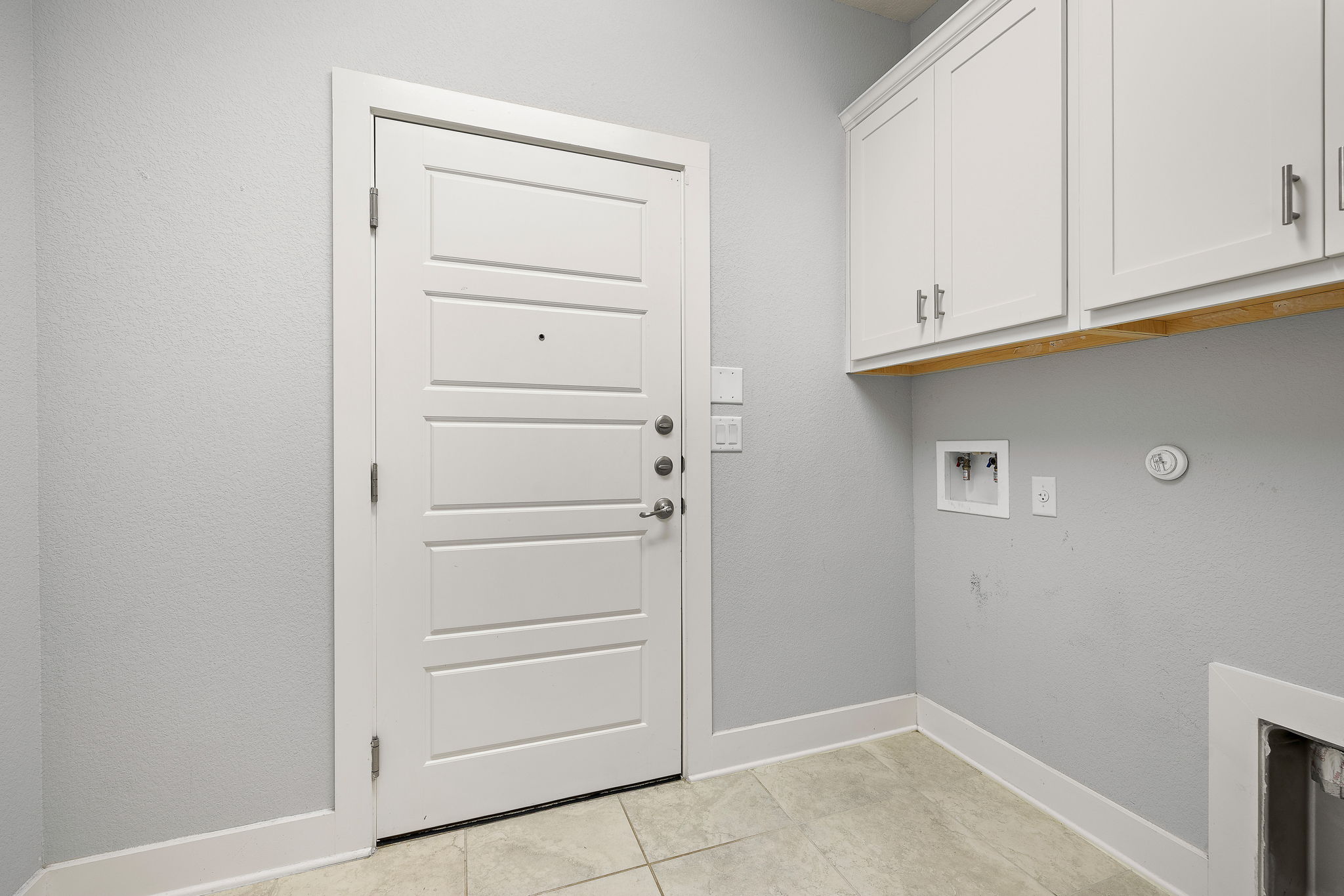 7520 Kinross Trail Austin, TX 78754 - Photo 26 of 37 Laundry room with hookup for a washing machine, hookup for a gas dryer, light tile patterned floors, and cabinet space