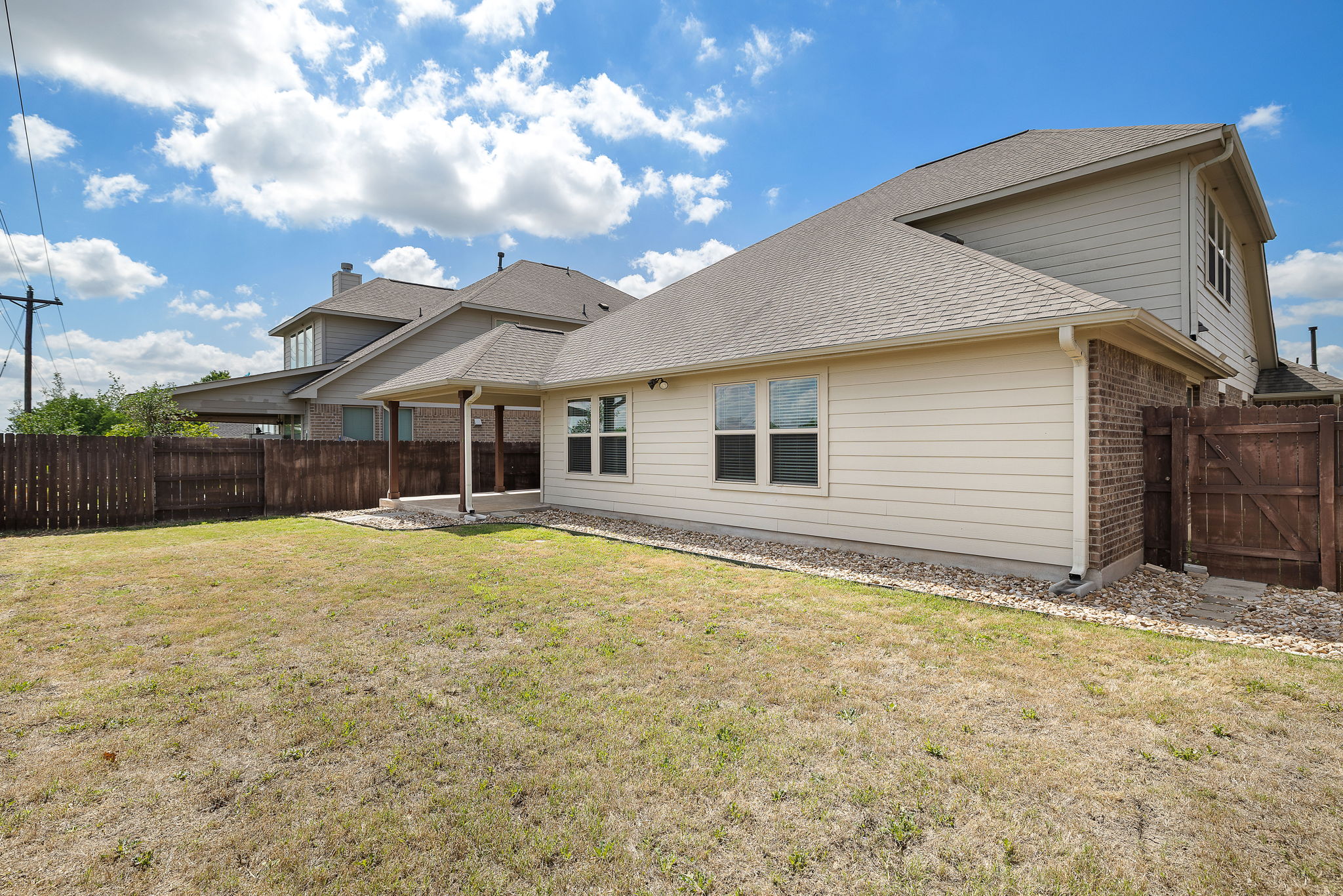 7520 Kinross Trail Austin, TX 78754 - Photo 33 of 37 Rear view of property featuring brick siding, a fenced backyard, a patio, a shingled roof, and a gate