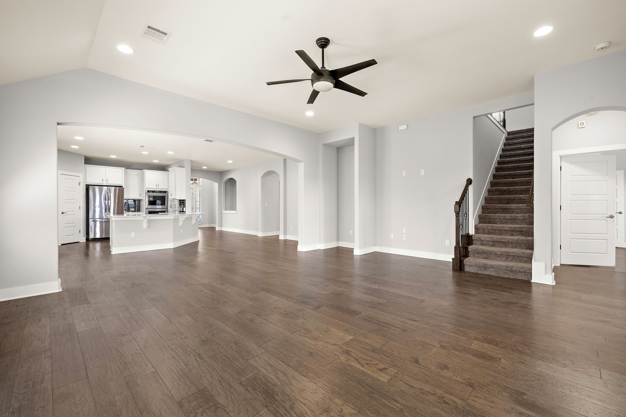 7520 Kinross Trail Austin, TX 78754 - Photo 7 of 37 Unfurnished living room featuring arched walkways, ceiling fan, recessed lighting, and dark wood-type flooring