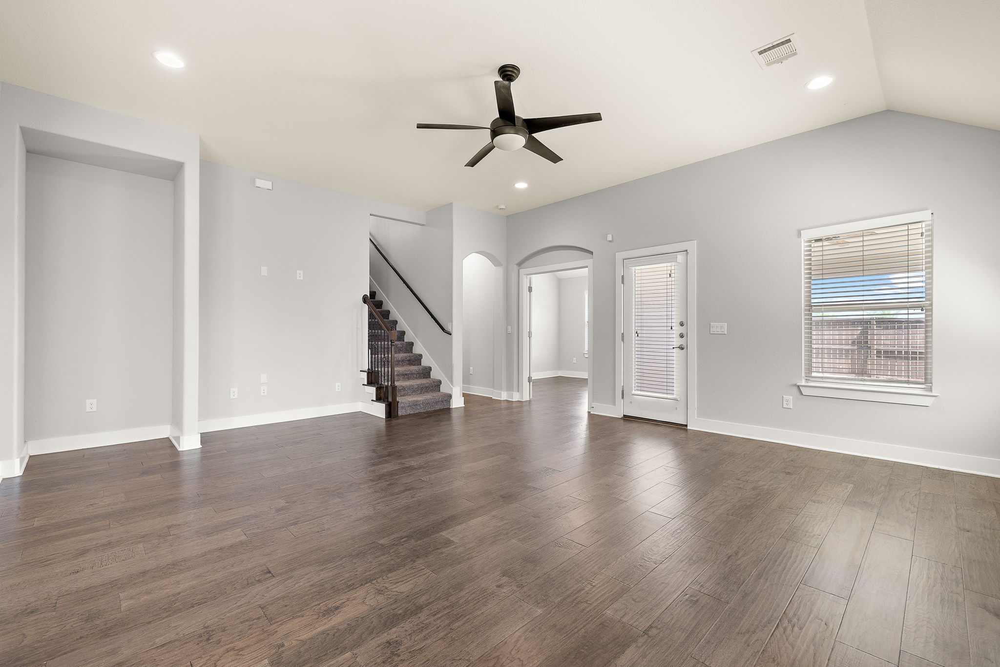 7520 Kinross Trail Austin, TX 78754 - Photo 8 of 37 Unfurnished living room featuring arched walkways, a ceiling fan, recessed lighting, and dark wood-style flooring