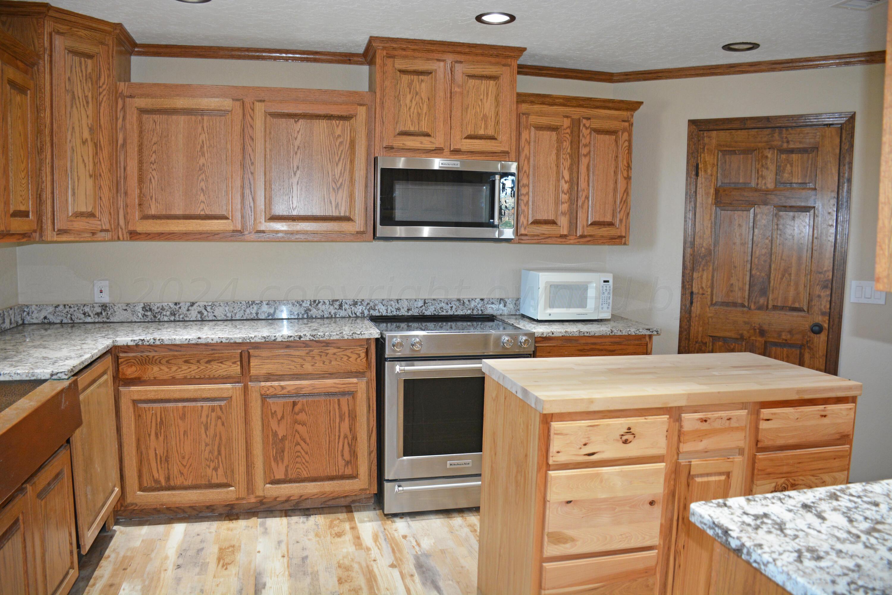 1159 Fm 1760 Muleshoe, TX 79347 - Photo 14 of 34 a kitchen with granite countertop a sink and cabinets