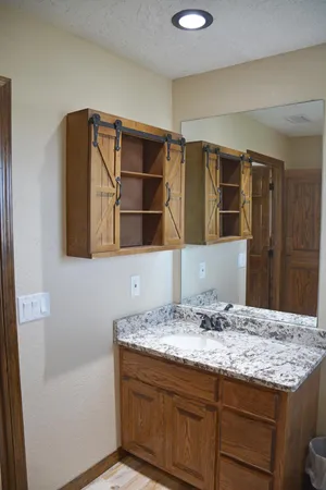 a bathroom with a granite countertop sink and a mirror