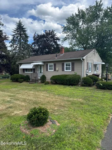a front view of house with yard and green space