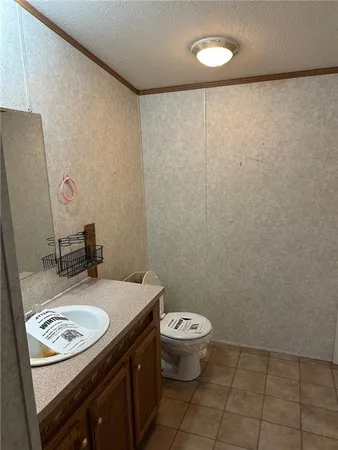 a bathroom with a granite countertop sink a toilet and a mirror