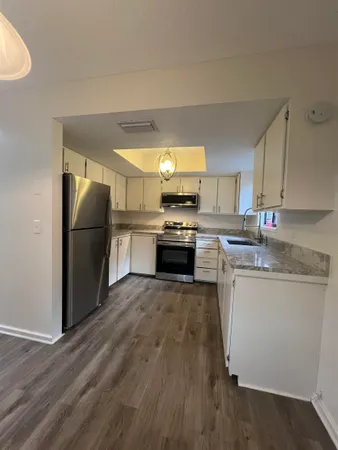 a kitchen with granite countertop a refrigerator stove top oven and sink
