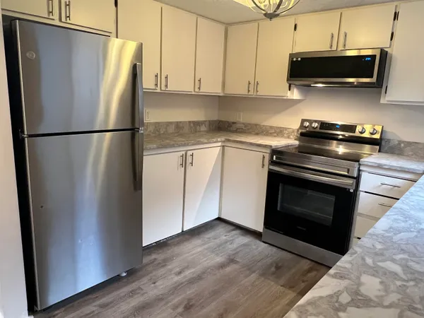 a kitchen with stainless steel appliances granite countertop a refrigerator stove and microwave