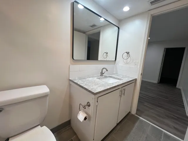 a bathroom with a granite countertop sink and a mirror