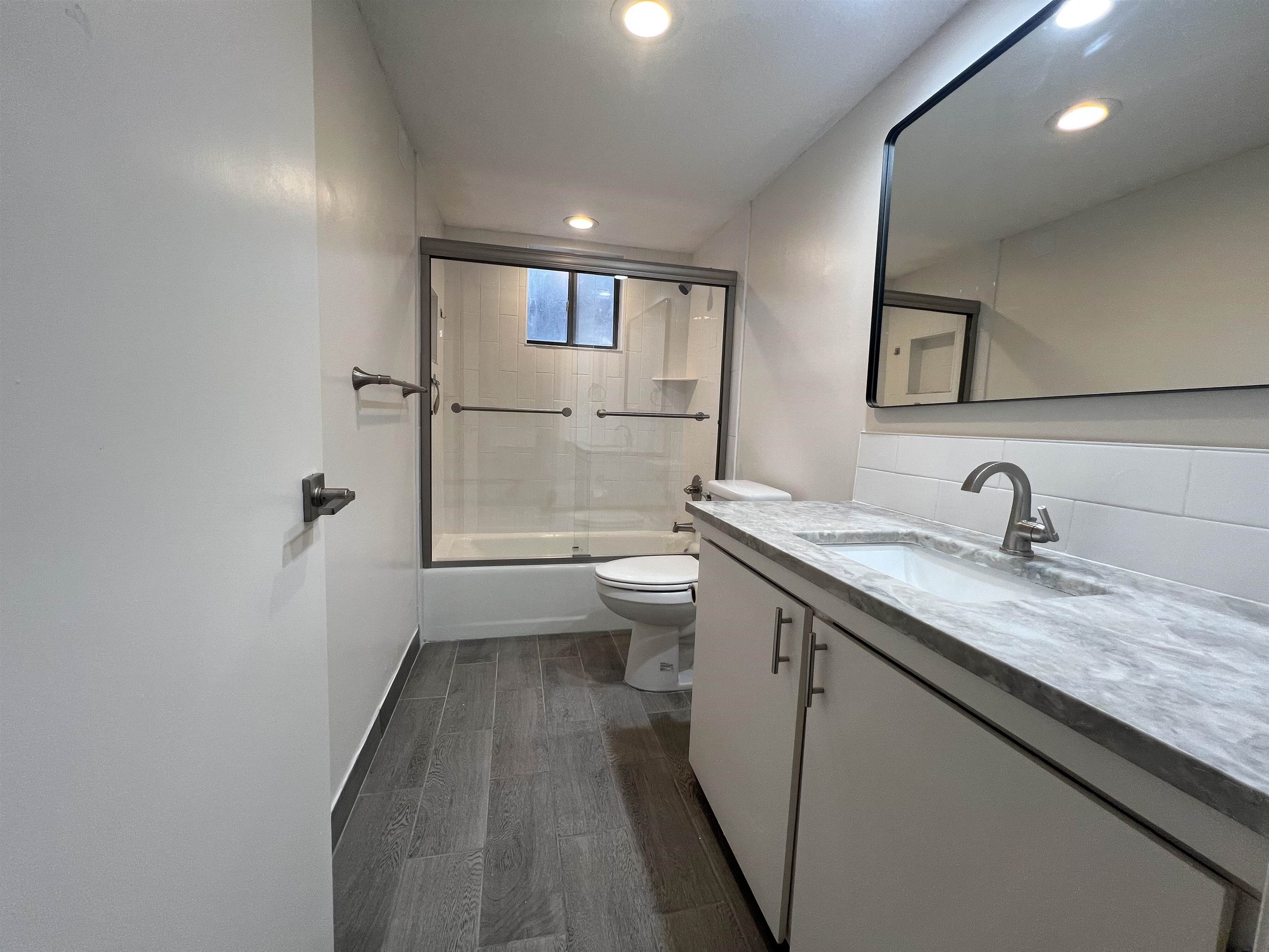 203 6th Street, Unit A St. Augustine, FL 32080 - Photo 5 of 21 a bathroom with a granite countertop sink a toilet and a mirror