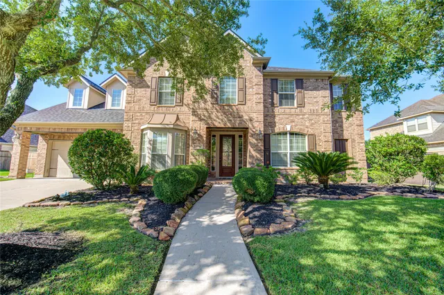 a front view of a house with a yard and potted plants