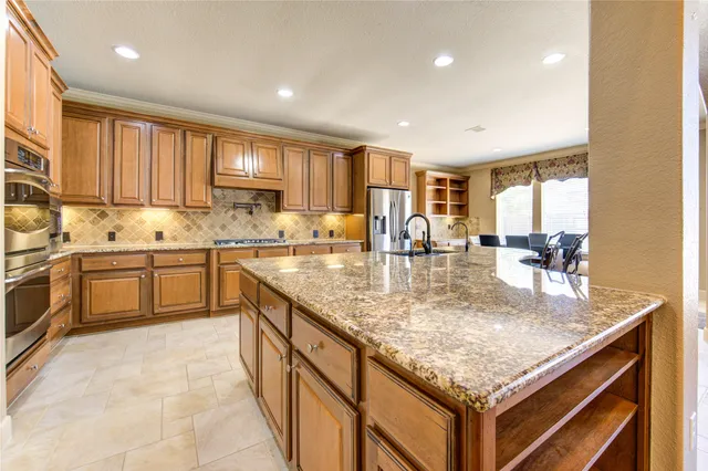 a kitchen with stainless steel appliances granite countertop a sink counter space cabinets and a large window
