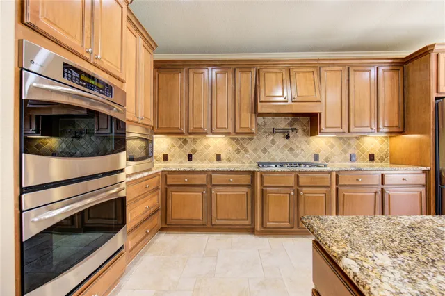a kitchen with granite countertop cabinets stainless steel appliances and a sink