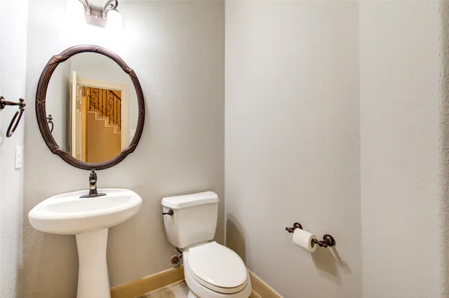 a bathroom with a sink toilet and a mirror