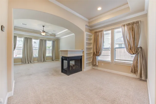 a view of an empty room with a fireplace and a window