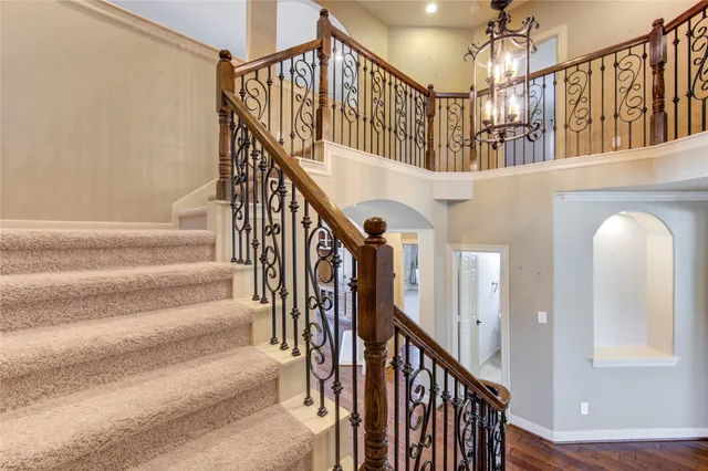 a view of staircase with lots of frames on wall and wooden floor