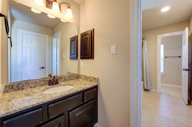a bathroom with a granite countertop sink and a mirror