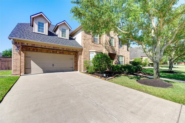 a front view of a house with garage and plants