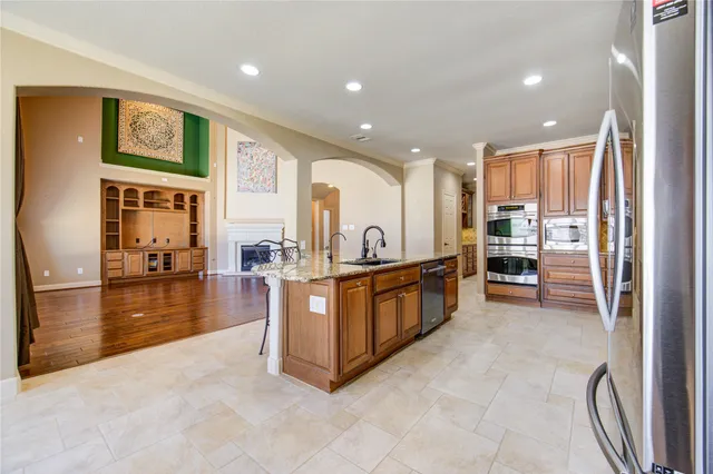 a large kitchen with stainless steel appliances granite countertop a large counter top and a stove