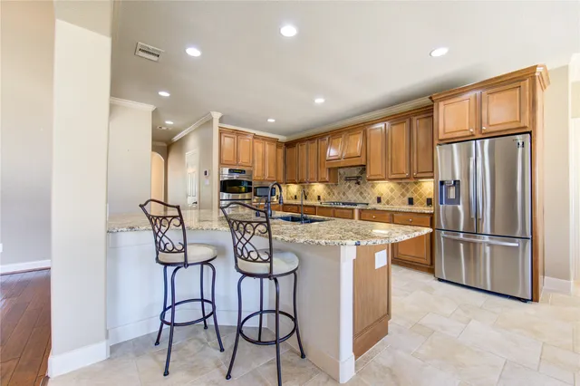 a kitchen with stainless steel appliances granite countertop a refrigerator and a sink