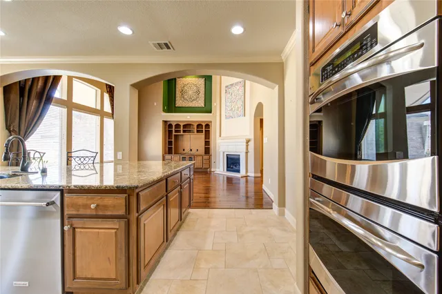 a kitchen with stainless steel appliances granite countertop a refrigerator a stove and a sink with wooden floor