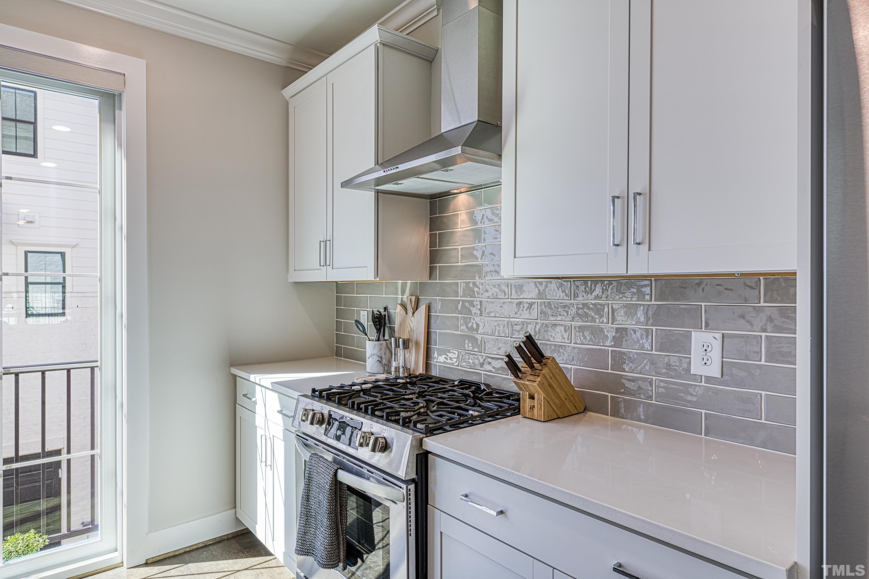 401 Bryan Pointe Drive, Unit 103 Raleigh, NC 27608 - Photo 11 of 33 a kitchen with granite countertop a stove and a white cabinets