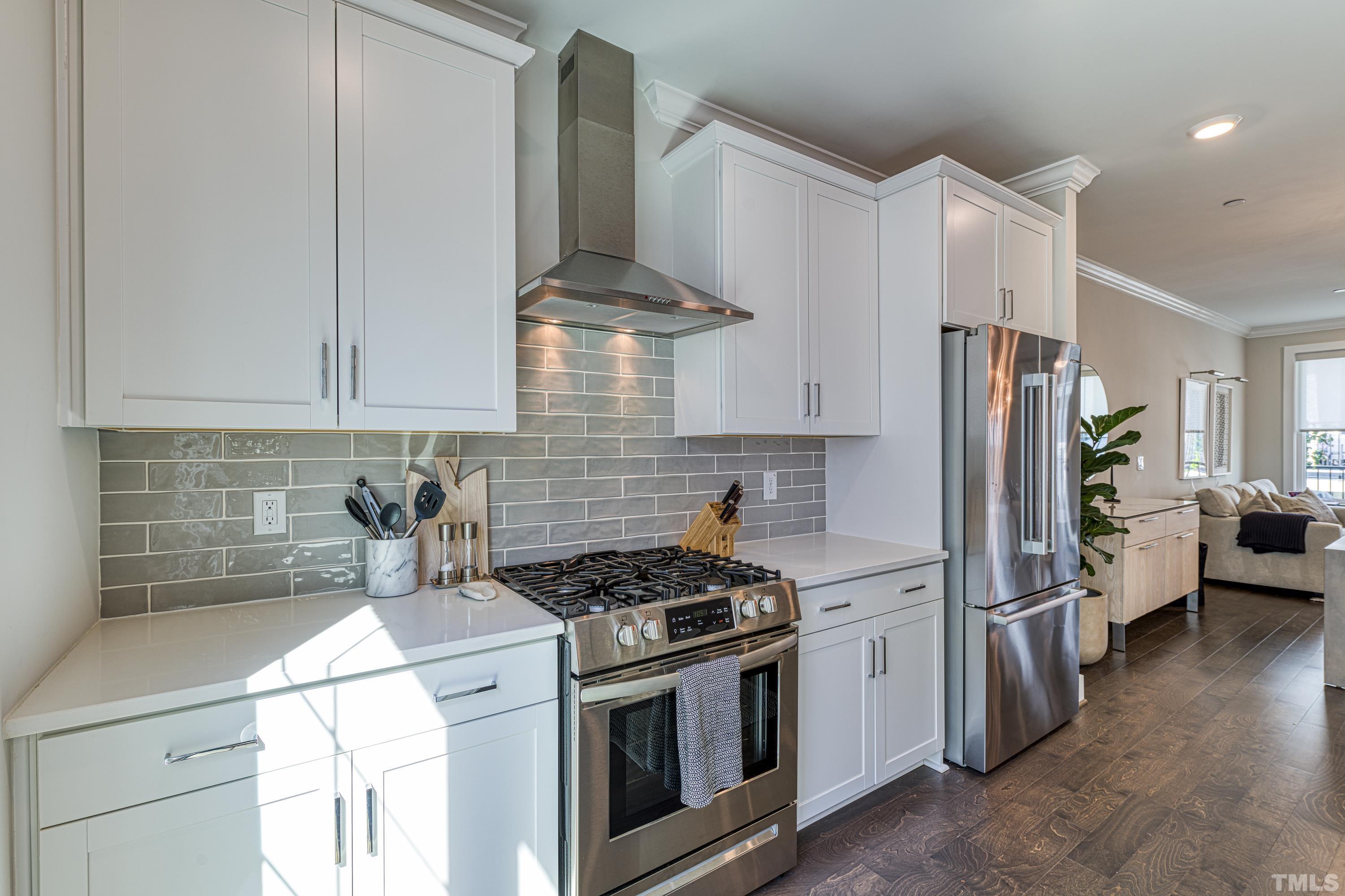 401 Bryan Pointe Drive, Unit 103 Raleigh, NC 27608 - Photo 12 of 33 a kitchen with stainless steel appliances a stove a refrigerator a sink a stove and white cabinets