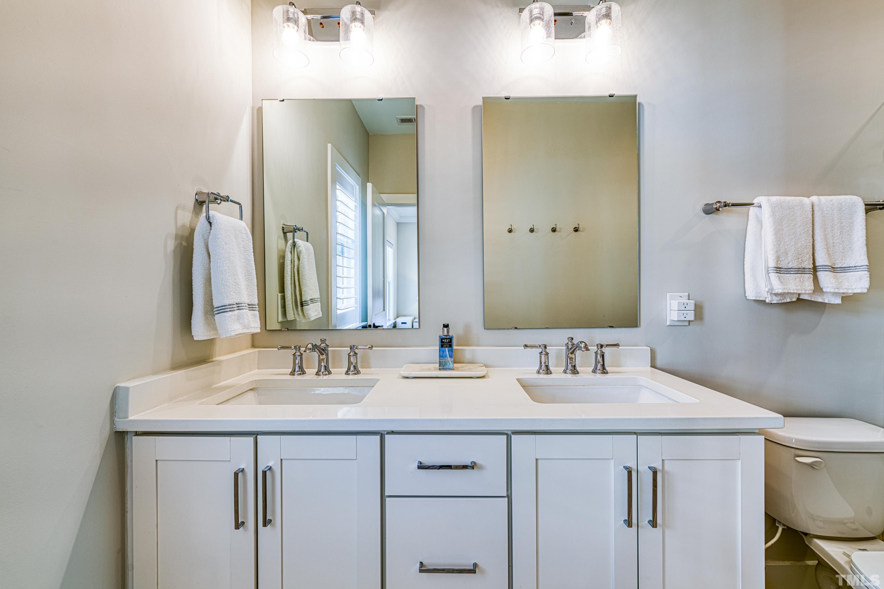 401 Bryan Pointe Drive, Unit 103 Raleigh, NC 27608 - Photo 27 of 33 a bathroom with double sink and a mirror