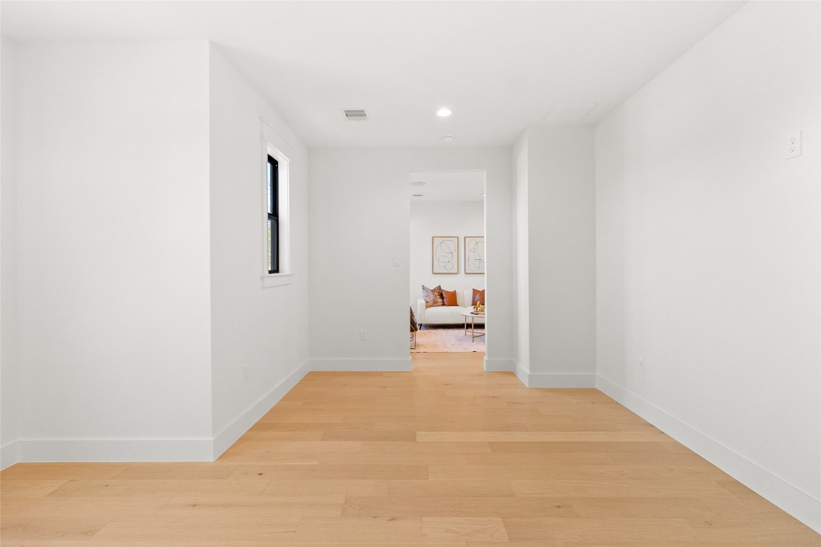 7115 Raton Street Houston, TX 77055 - Photo 17 of 49 You step into this private speakeasy-style room tucked away from the main living areas—a clean, minimalist space designed to transform into whatever your lifestyle calls for. Whether you envision a hidden lounge, tasting room, or vinyl listening space, the crisp white walls and warm wood floors give you a blank canvas to create something truly personal and unexpected.