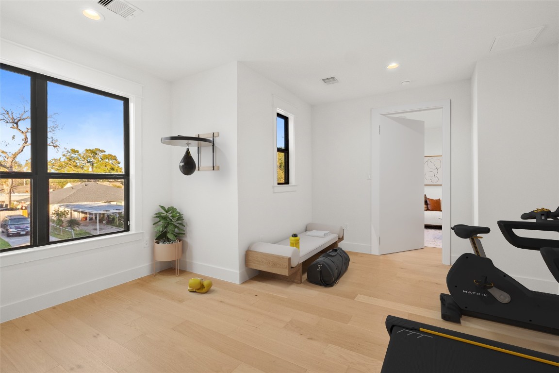 7115 Raton Street Houston, TX 77055 - Photo 19 of 49 From this angle, the speakeasy room showcases its flexibility and thoughtful design, with natural light pouring in through oversized windows and ample wall space for multiple layouts. The discreet Murphy door integrated along the left wall adds a hidden architectural element, allowing the room to remain clean-lined and uncluttered while offering seamless access without breaking the aesthetic.