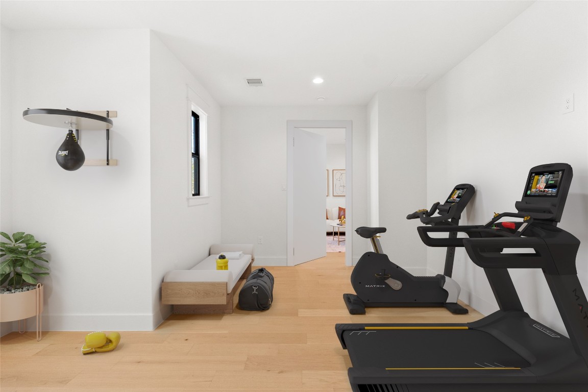 7115 Raton Street Houston, TX 77055 - Photo 20 of 49 This view emphasizes the room’s versatility and flow, virtually staged to demonstrate a gym configuration while still leaving generous open space. The speakeasy layout makes this room feel intentional and private, perfect for anything from fitness and meditation to a media room or creative retreat. The concealed entry reinforces the “hidden room” feel, adding both function and character.