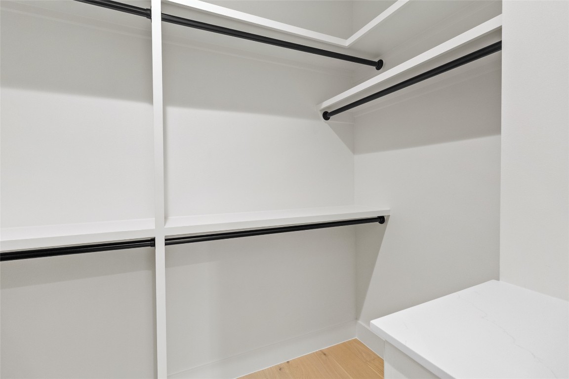 7115 Raton Street Houston, TX 77055 - Photo 44 of 49 Your walk-in closet is thoughtfully designed with custom shelving and dual hanging rods that make staying organized effortless. There’s room for everything—from everyday essentials to seasonal pieces—plus built-in counter space that’s perfect for accessories, storage bins, or folding laundry with ease.