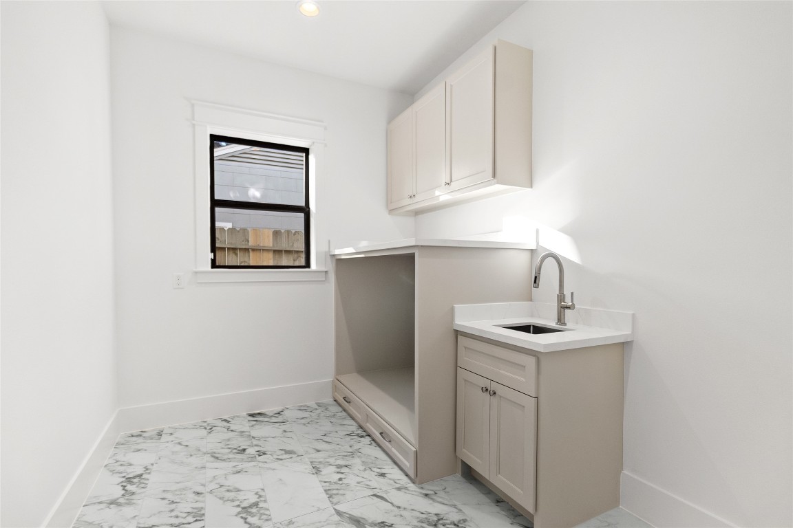 7115 Raton Street Houston, TX 77055 - Photo 45 of 49 Laundry day feels effortless in this bright, thoughtfully designed space. You’ve got custom cabinetry for storage, a deep utility sink for handwashing or cleanups, and generous counter space that makes folding and organizing feel simple instead of rushed.