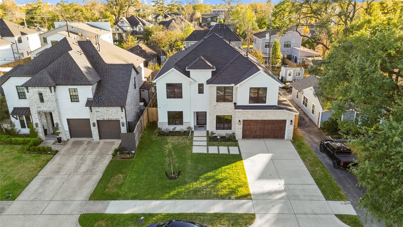 7115 Raton Street Houston, TX 77055 - Photo 47 of 49 Your modern exterior stands out immediately, blending crisp white tones with warm brick accents and dark-framed windows that give the home a clean, contemporary presence from the street.