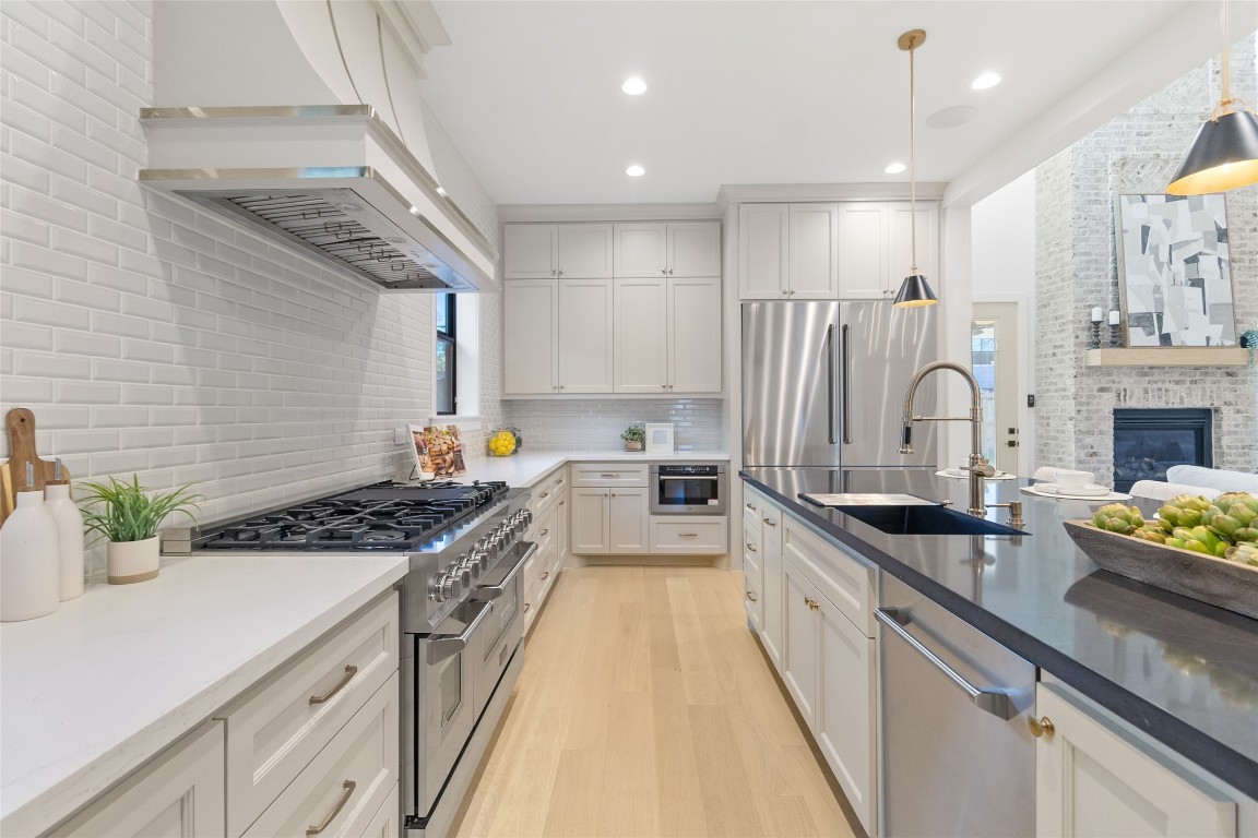 7115 Raton Street Houston, TX 77055 - Photo 8 of 49 From this angle, the island becomes the heart of the home. You’ve got seating for casual meals, a deep sink for easy cleanup, and a clear sightline into the living area so nothing feels disconnected. The stainless appliances, custom cabinetry, and warm wood floors balance clean design with livability—this is a kitchen you actually use, not just admire.